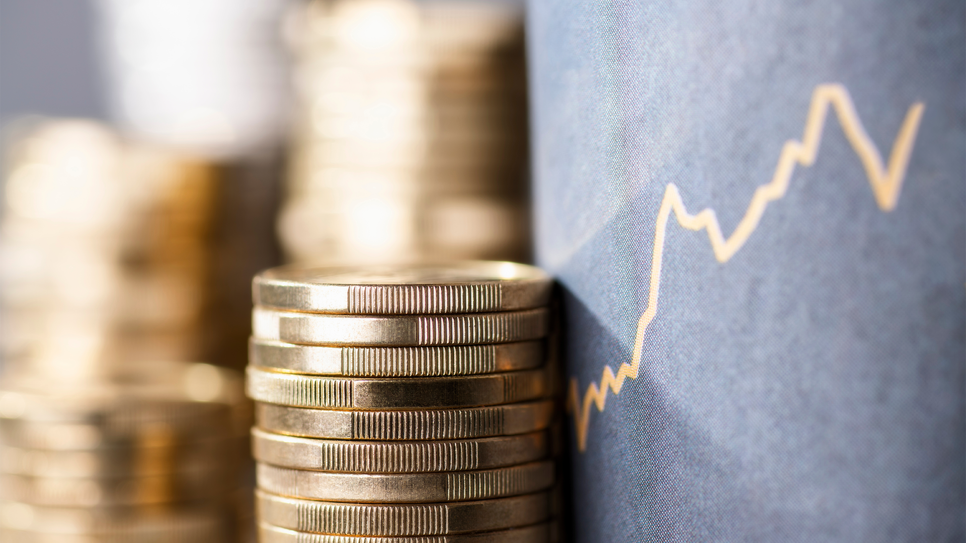 A pile of US dollar coins and a market chart amid Oil Continues to Climb, and the Dollar Is Trying to Consolidate