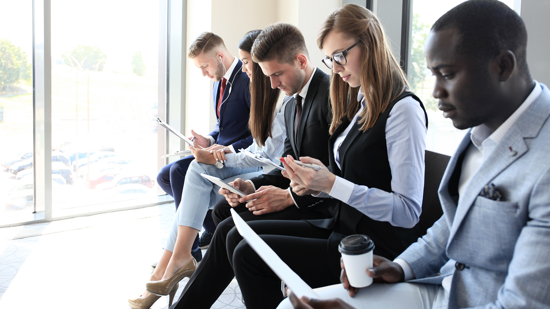 5 company employees with mixed nationalities sitting on a bench.