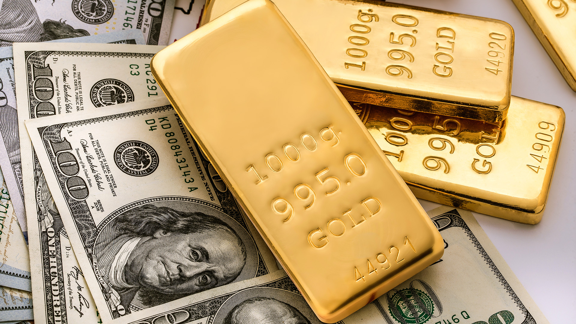Gold bars and US dollars amid The US Dollar Is Declining While Gold Remains Stable